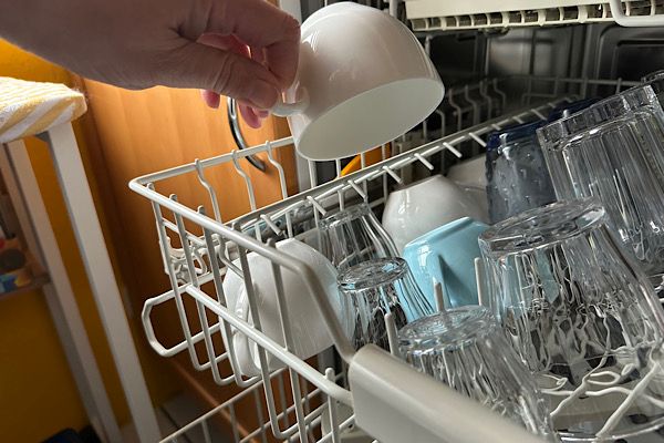 Eine Tasse wird aus der Spülmaschine genommen