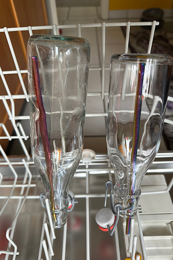 Glasflasche auf Strohhalm in der Spülmaschine